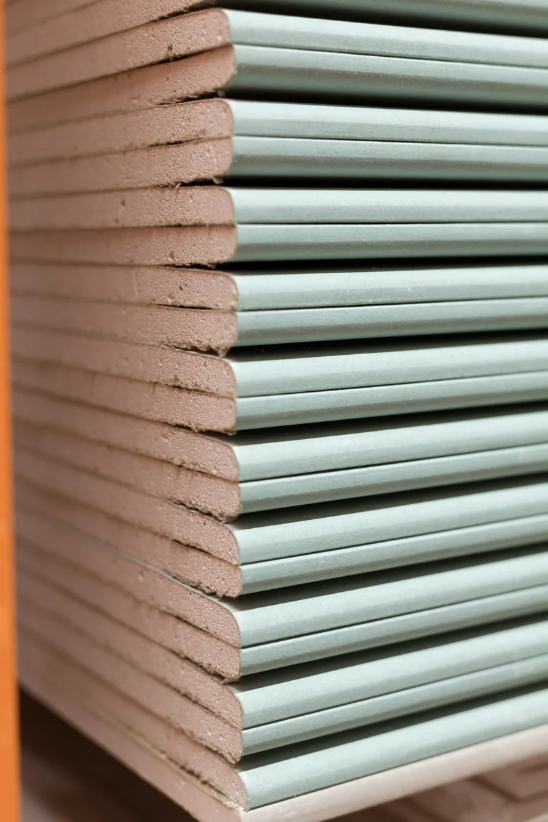Close-up of stacked green moisture-resistant board edges