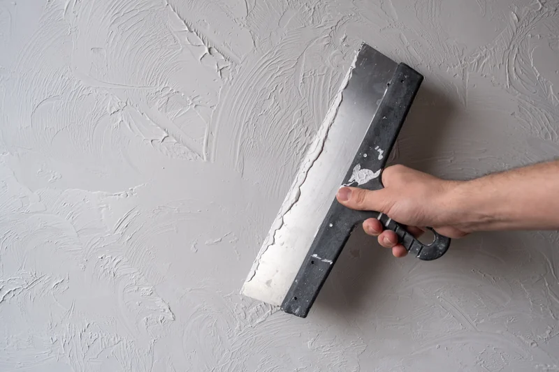 Wide knife drawn across a knockdown-textured wall