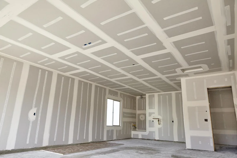 Taped ceiling and walls in an unfinished room