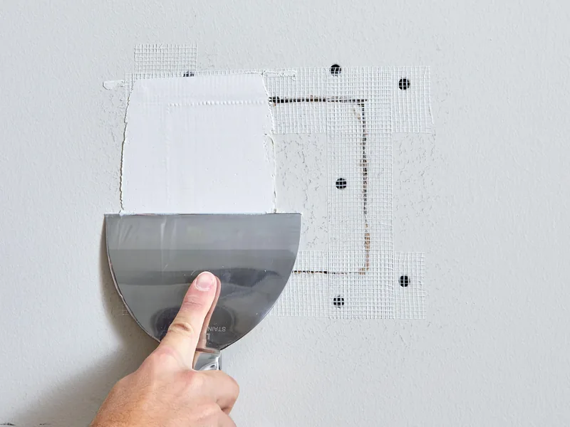 Drywall patch feathered and blended into the surrounding wall