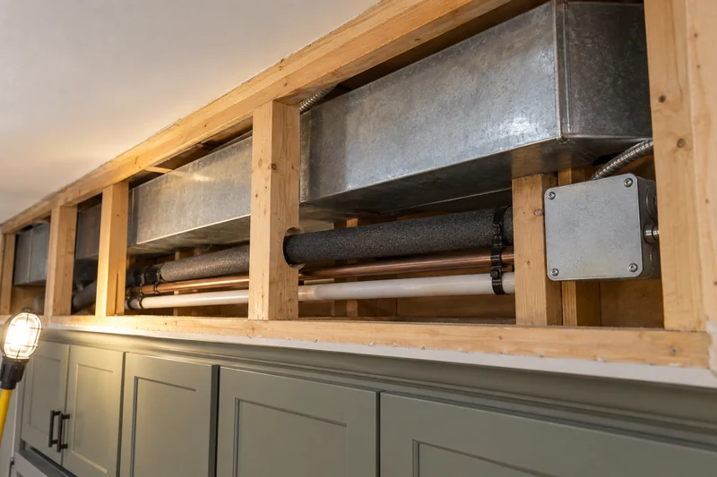 Opened soffit showing the duct, pipes and junction box running inside it